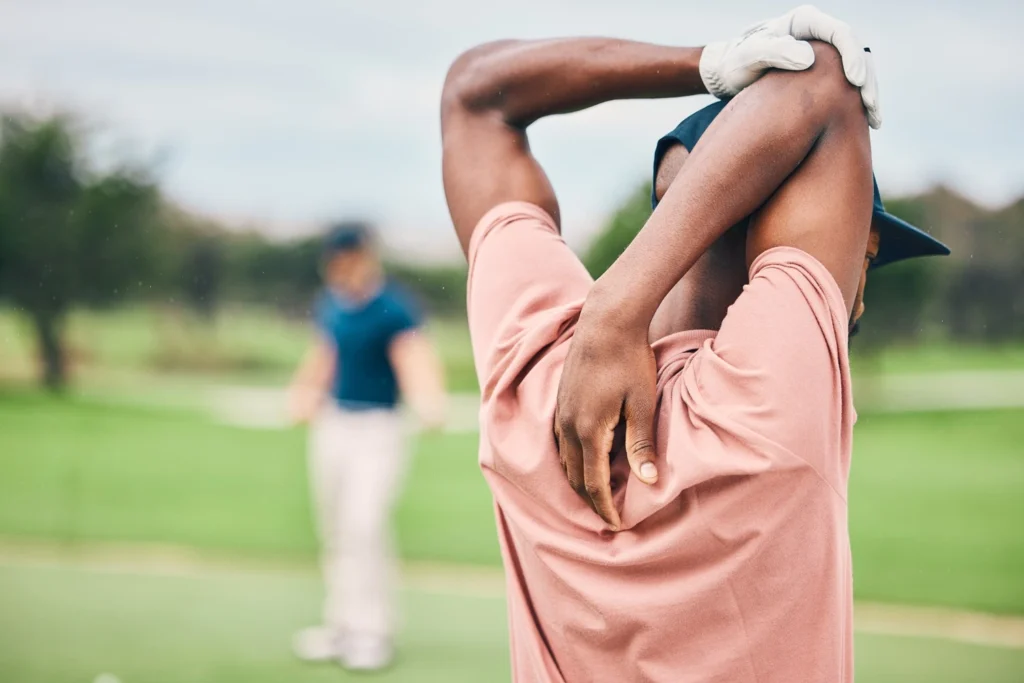 Golf player stretching arms on course for game, practice and training for competition.