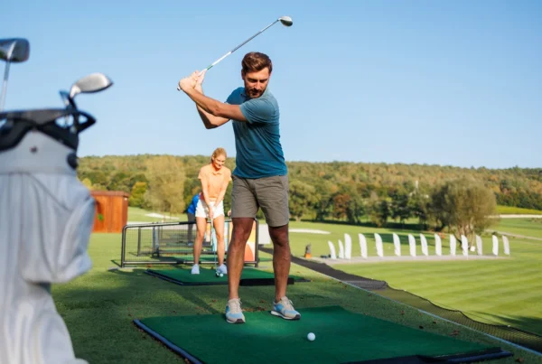 Young Pair learning how to play golf on a driving range